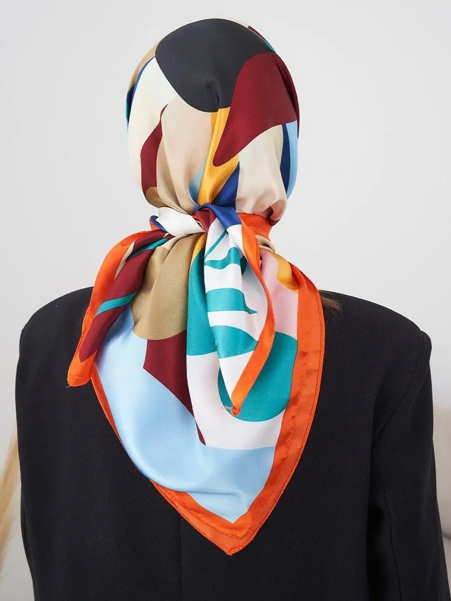 Foulard carré 70x70, soyeux au toucher, imprimé floral multicolore, bordure orange vive, accessoire mode polyvalent, modèle Kalya