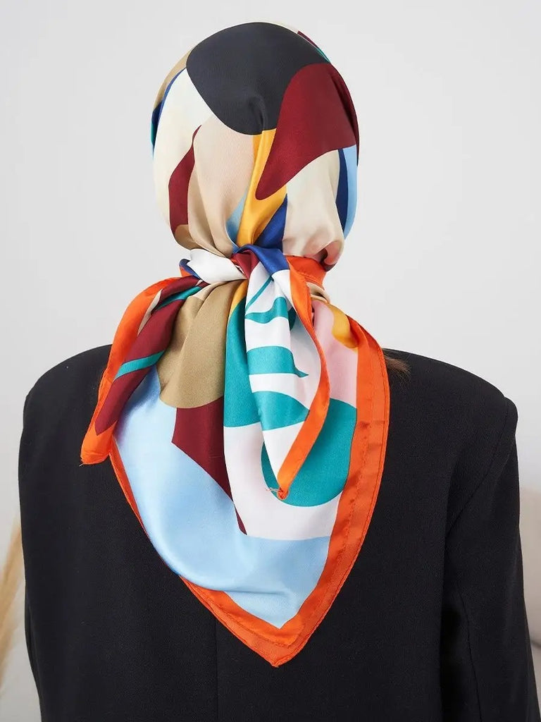 Foulard carré 70x70, soyeux au toucher, imprimé floral multicolore, bordure orange vive, accessoire mode polyvalent, modèle Kalya